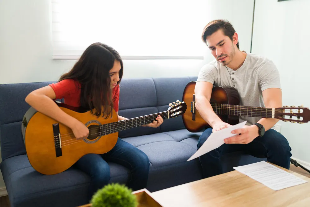 Teacher and student playing guitars