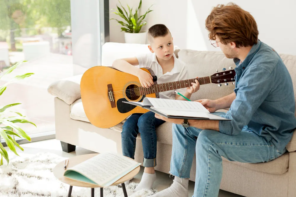 Teacher and young student with guitar