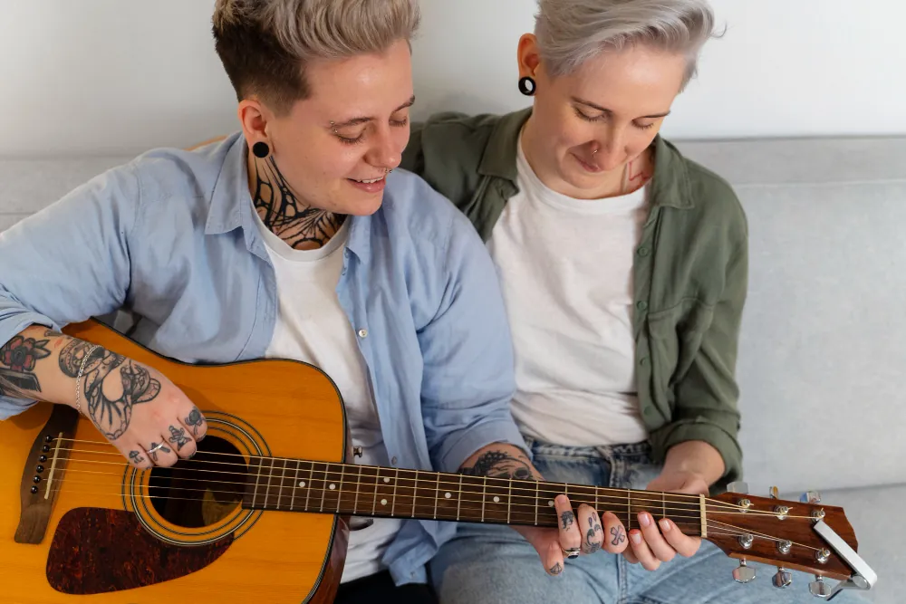 Two adults learning guitar